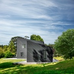 Na samotě u lesa si postavili černý dům s bílým interiérem. Foto: Martin Gardner
