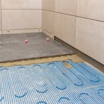 Elektrická topná rohož se často pokládá napřípklad do koupelen pod dlažbu přímo do lepidla. Má minimální nároky na tloušťku podlahy. Zdroj: AdobeStock – wabeno