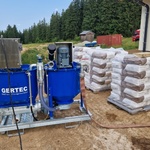 Pytlovaný injektážní materiál na paletách, zařízení pro míchání směsi a injektážní čerpadlo pro tlakovou injektáž vrtů. Zdroj: Gerotop