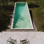 Venku se mezi divokými borovicemi, rovnoběžně s mořem, nachází dlouhý bazén. Krajina byla téměř nedotčena. Všechny stávající stromy byly zachovány a na svazích byla vysazena řada ovocných stromů, aby se zachoval zemědělský charakter okolí. Foto: Clemens Poloczek