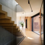 Schodiště z masivního dřeva propojuje úrovně domu s lehkostí a přirozeností. Jeho linie navádí pohled vzhůru, k prostoru otevřenému až po hřeben střechy, podél masivní betonové stěny. Foto: Nate Cook Photography Schodiště z masivního dřeva propojuje úrovně domu s lehkostí a přirozeností. Jeho linie navádí pohled vzhůru, k prostoru otevřenému až po hřeben střechy, podél masivní betonové stěny. Foto: Nate Cook Photography