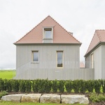 Zvenčí jsou budovy obloženy předem zvětralým dřevem a zastřešeny tradičními pálenými taškami. Forma je známá a klidná, výraz střídmý, ale konstrukce přesná a promyšlená. Foto: Sebastian Schels