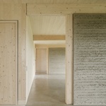 V přízemí je tato myšlenka rozvinuta pomocí stěn a podlah z hlíny. Tyto povrchy akumulují teplo, vyrovnávají vlhkost v interiéru a tlumí hluk. Foto: Sebastian Schels