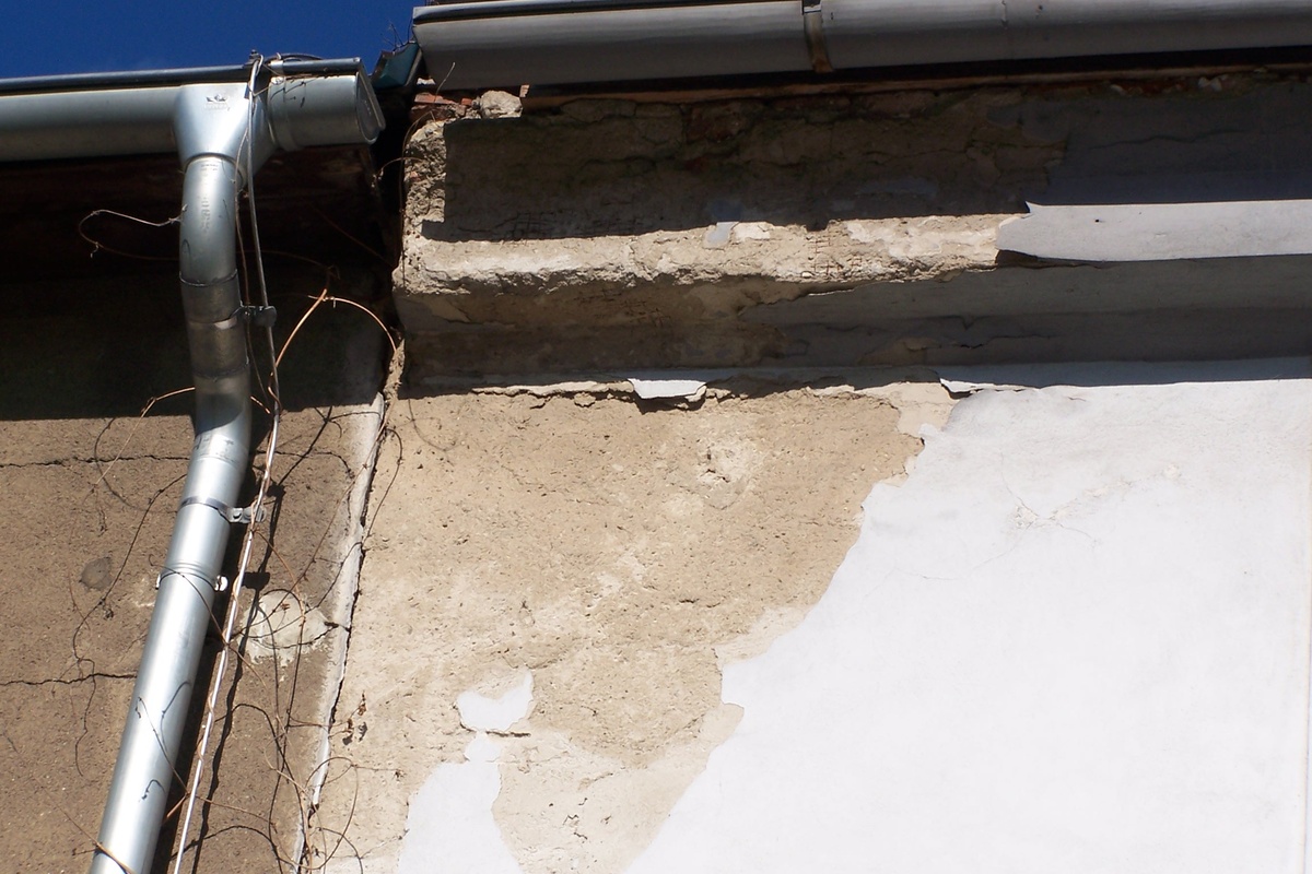 Chybným napojením střech a okapových žlabů dochází k dlouhodobému zatékání, což má za následek degradaci omítky a zdiva římsy.