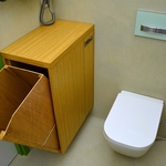 Vedle WC je umístěn výklopný prádelník obsahující v zadní části i úložný prostor, který je řešený na míru ostravskou firmou Stolařství Šindler. Nad prádelníkem je umístěno elektrické topení