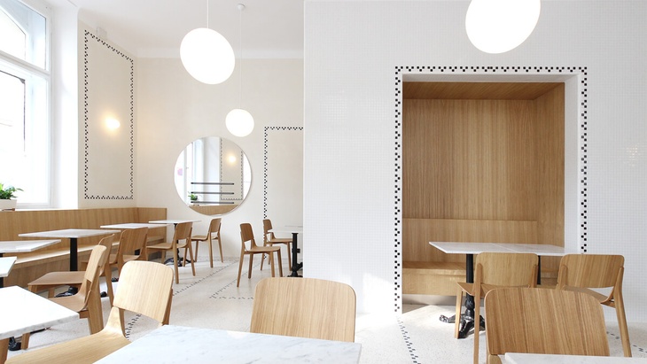 Světlý a otevřený interiér kavárny v Nové radnici respektuje historickou budovu