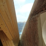 Průhled proskleným oknem mezi novým krovem a štítovou zdí. Autor: Ing. arch. Jakub Kopecký 
