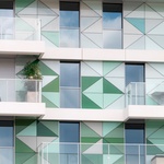 Bytový dům ve Francii s fasádou, kombinující kontaktní zateplovací systém StoTherm Classic, předsazený provětrávaný zateplovací systém StoVentec Glass, složený ze skleněných panelů různých tvarů a bílý fasádní povrch  StoSignature