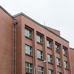Schodišťové šachty na sebe upozorňují pásy vertikálních oken a vytažením nad zbytek hmoty budovy.