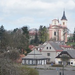 Kostel s klášterem (vlevo za stromy) a opravenou budovou č.2 (zcela vlevo) nad městem Nová Paka