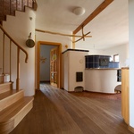 Schodiště na severu domu s úložným prostorem pod schodištěm. Schodnice, madlo i vnitřní dveře jsou natřené přírodním olejem